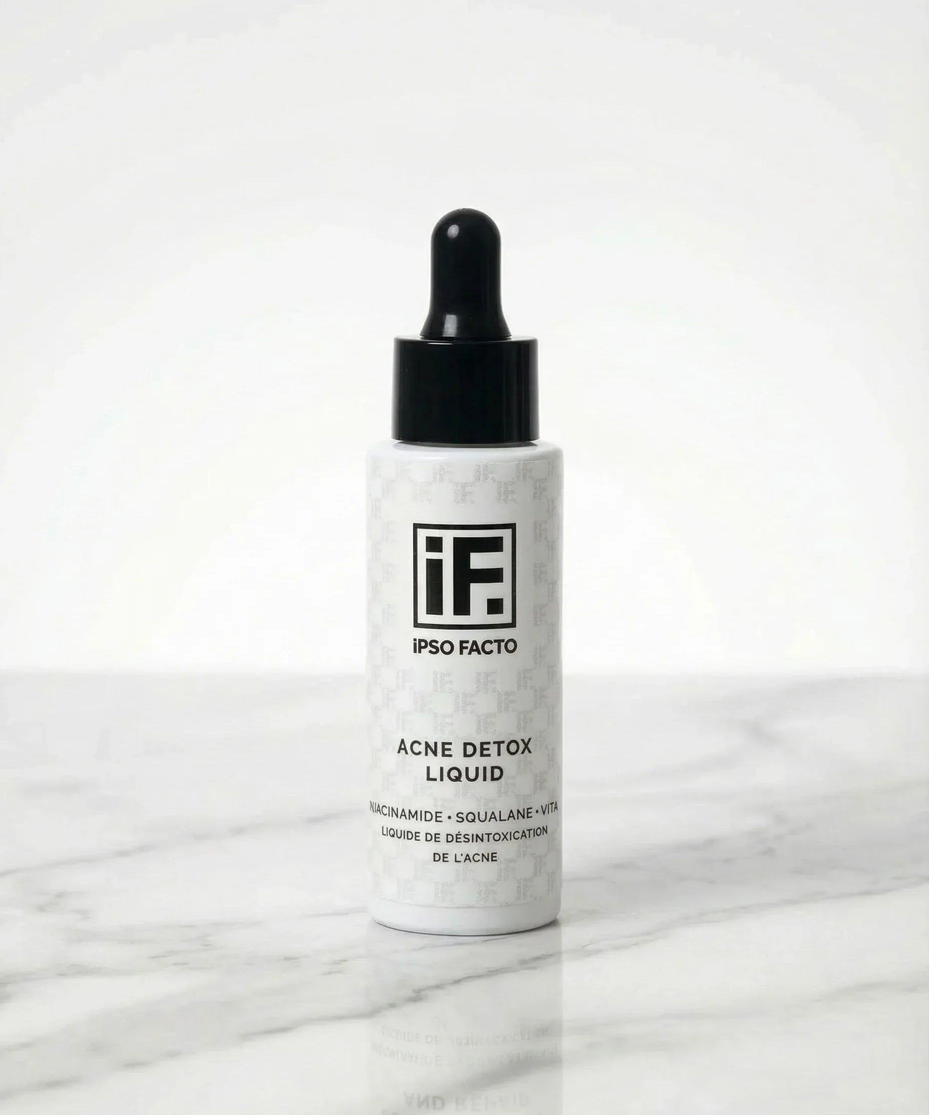 Acne Detox Liquid serum bottle with dropper on white marble background, skincare product