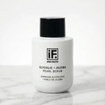 Glycolic and jojoba pearl scrub bottle on marble surface, minimalist skincare product