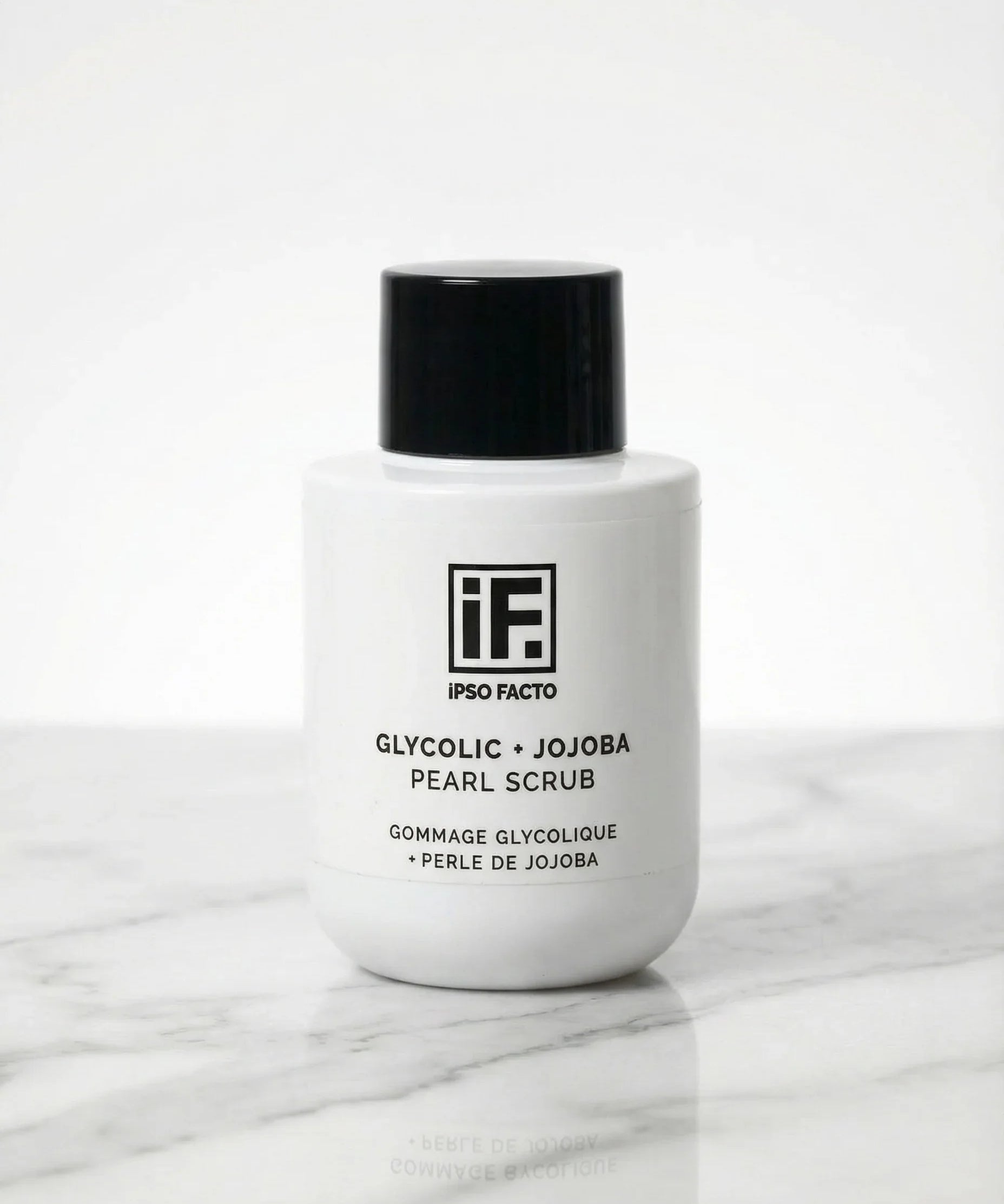 Glycolic and jojoba pearl scrub bottle on marble surface, minimalist skincare product