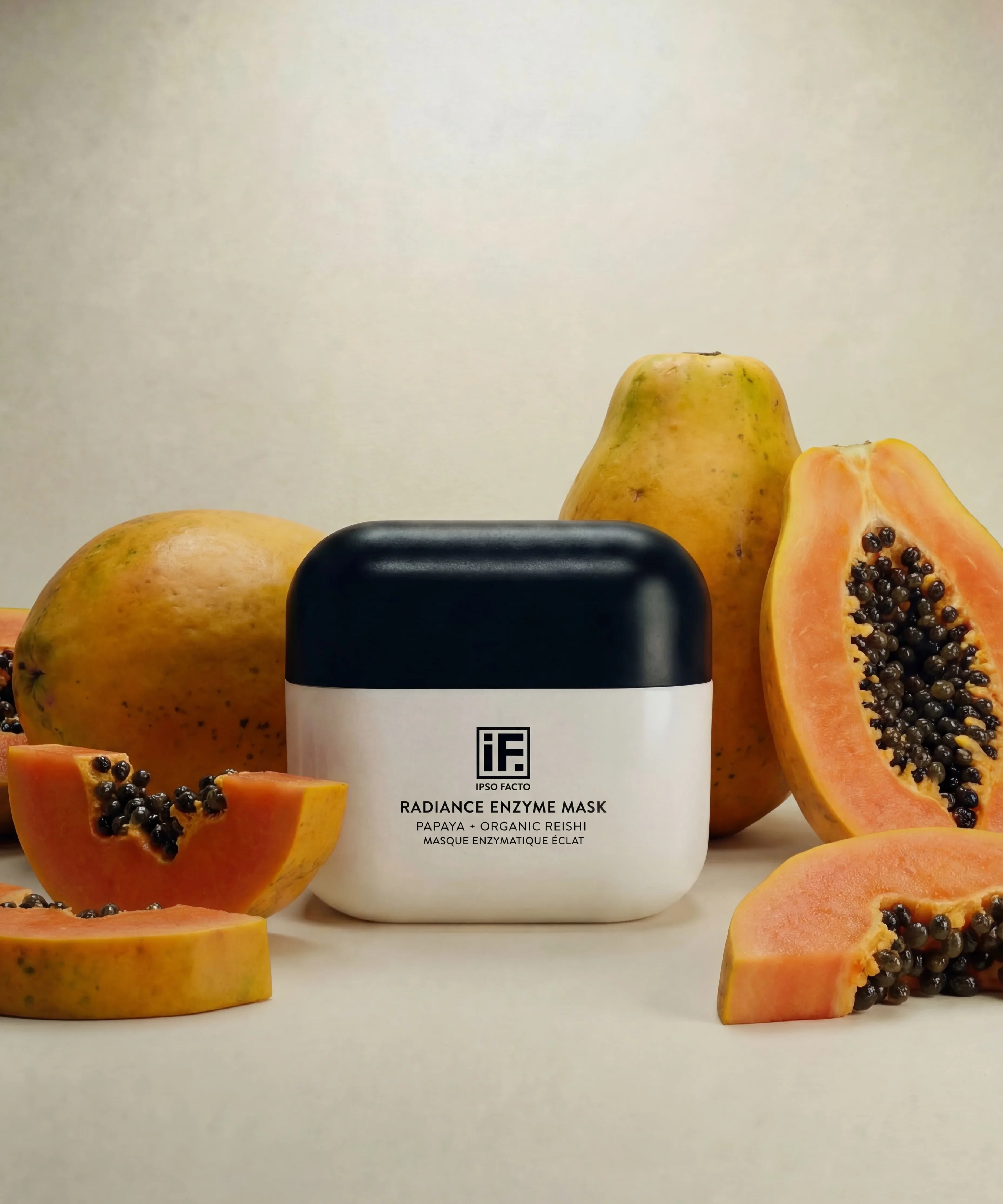Radiance Enzyme Mask jar with papaya fruit slices on a neutral background, skincare product