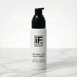 Retinol 2.5% night serum bottle with black pump on marble surface, skincare product