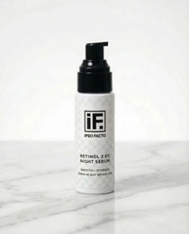 Retinol 2.5% night serum bottle with black pump on marble surface, skincare product