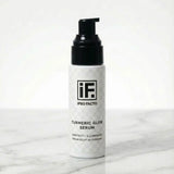 Turmeric Glow Serum skincare bottle with pump on white marble background